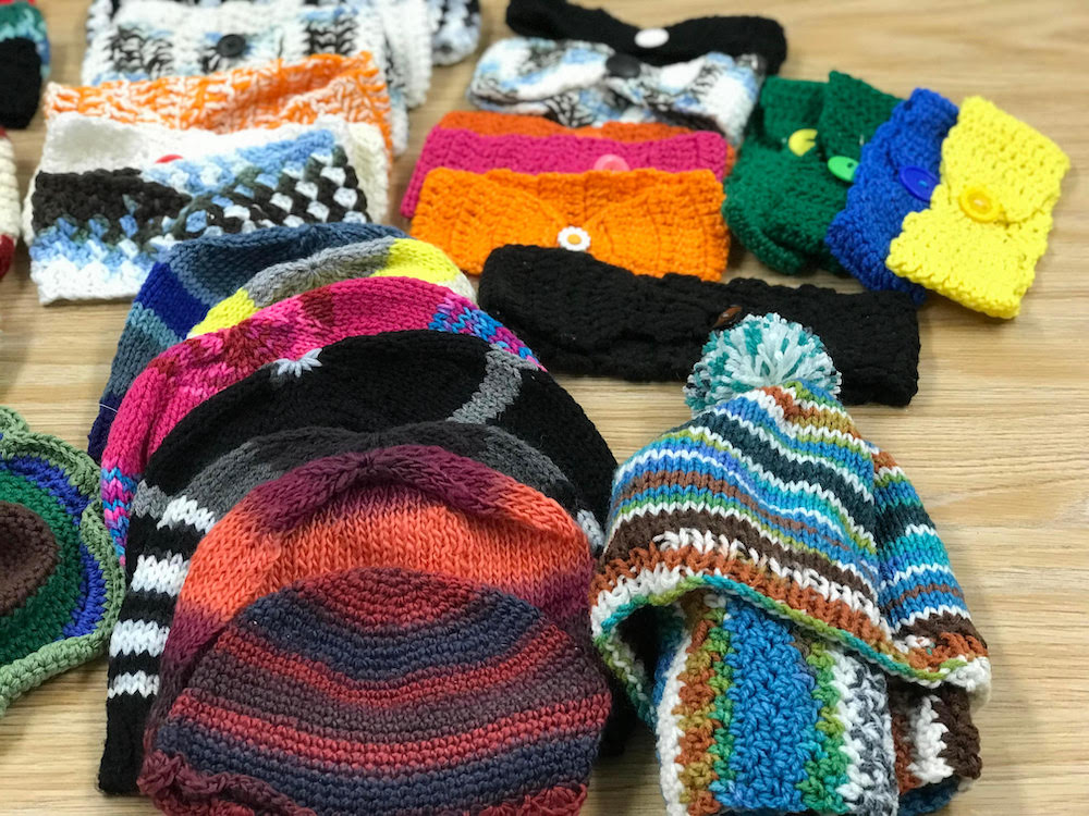 Library Crochet & Knitting with Eva class participants donating handmade items to local blessing box